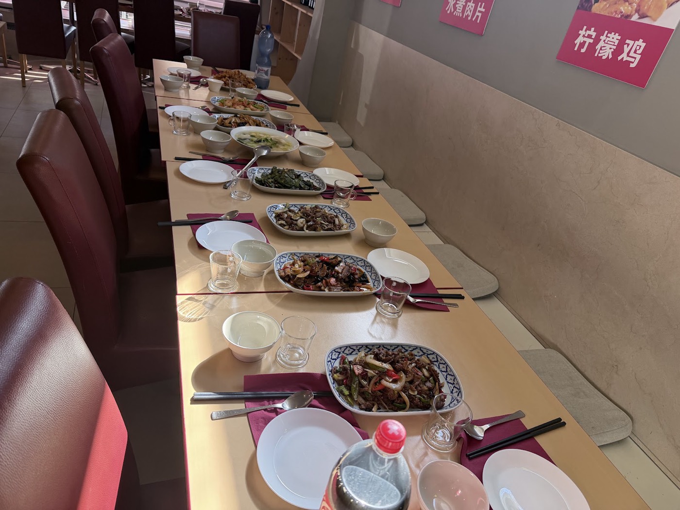 La salle du restaurant, tables dressées sous les placards de plats aux murs