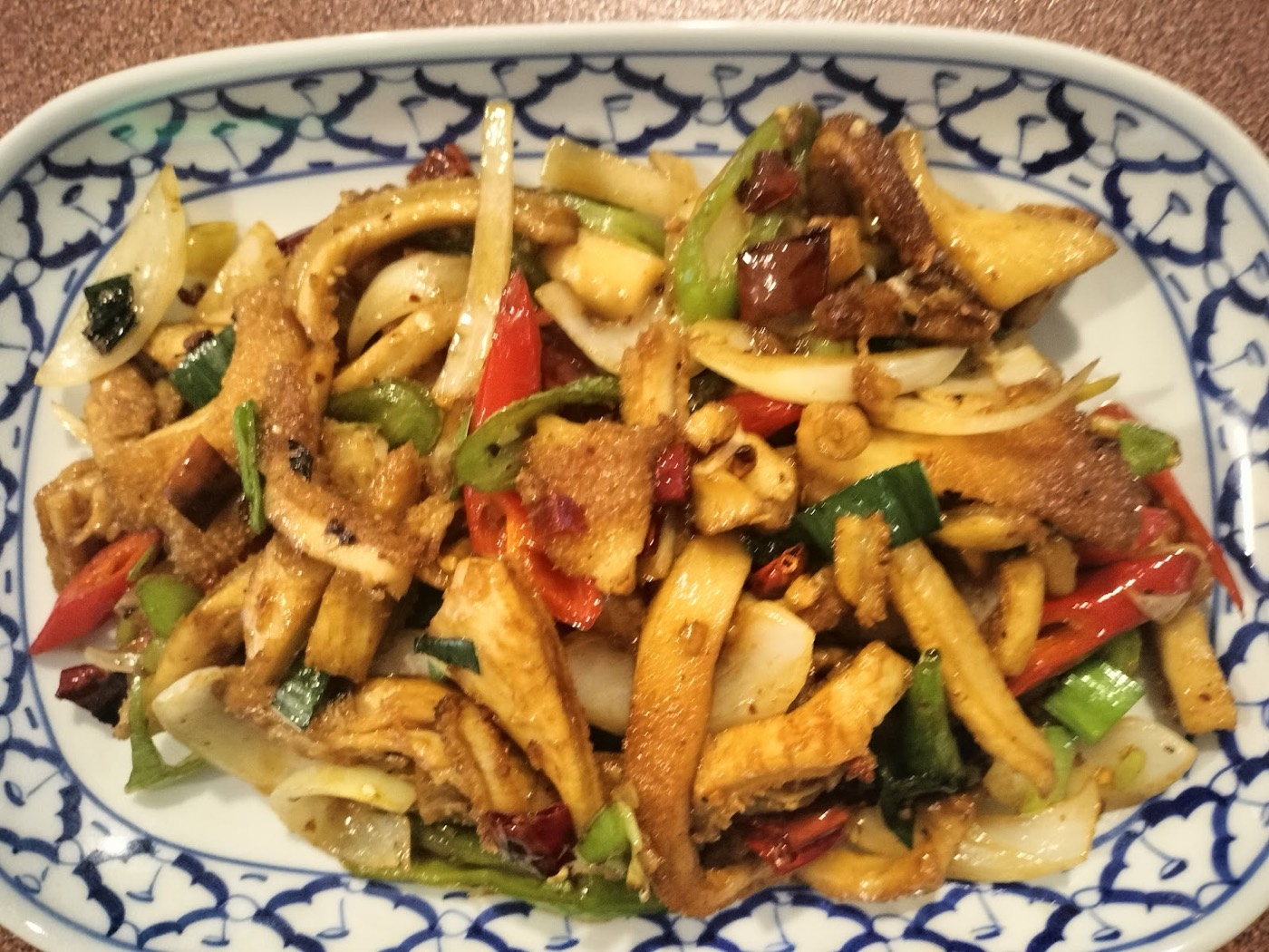 Sauté croustillant aux piments servi sur assiette en porcelaine bleue et blanche